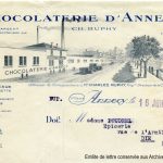 Archives municipales Annecy. 17 Fi 635. En-tête document Chocolaterie d’Annecy (détail), 1929, vue de l’usine, du quai de la Tournette et du port